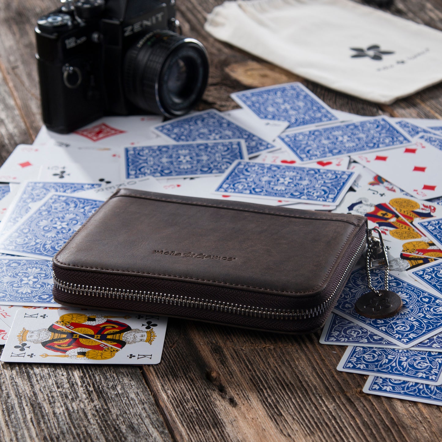 Dark Brown MELIA leather playing card case with playing cards arranged on a table