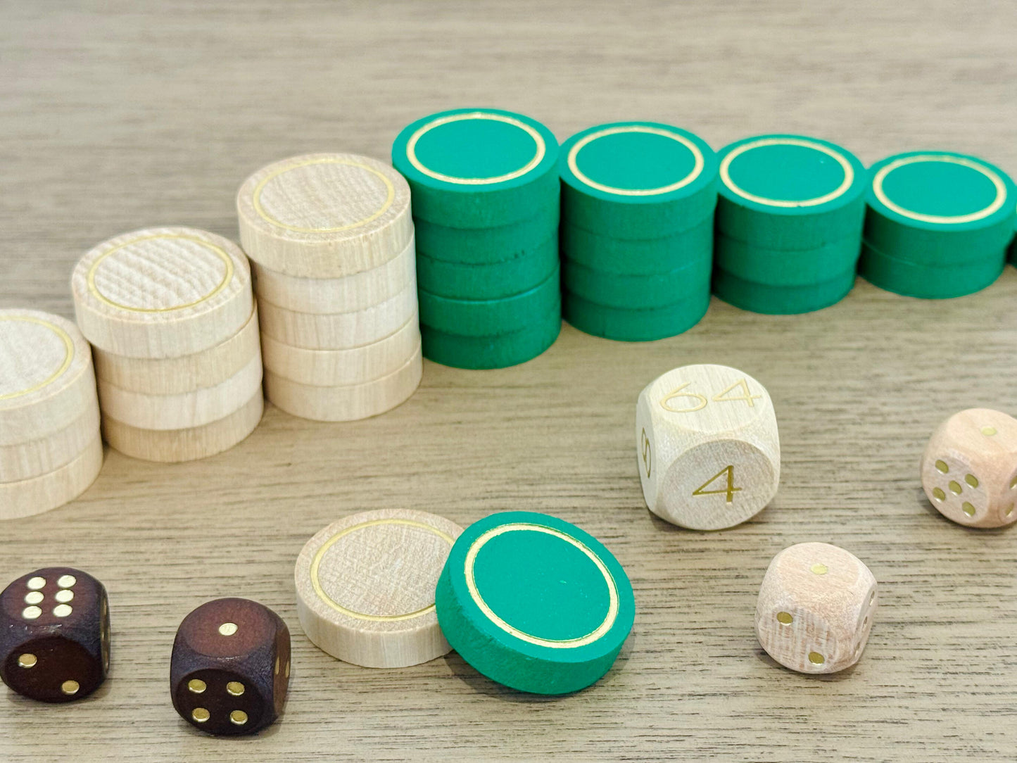 Green and cream wooden backgammon checkers with double-sided gold detailing