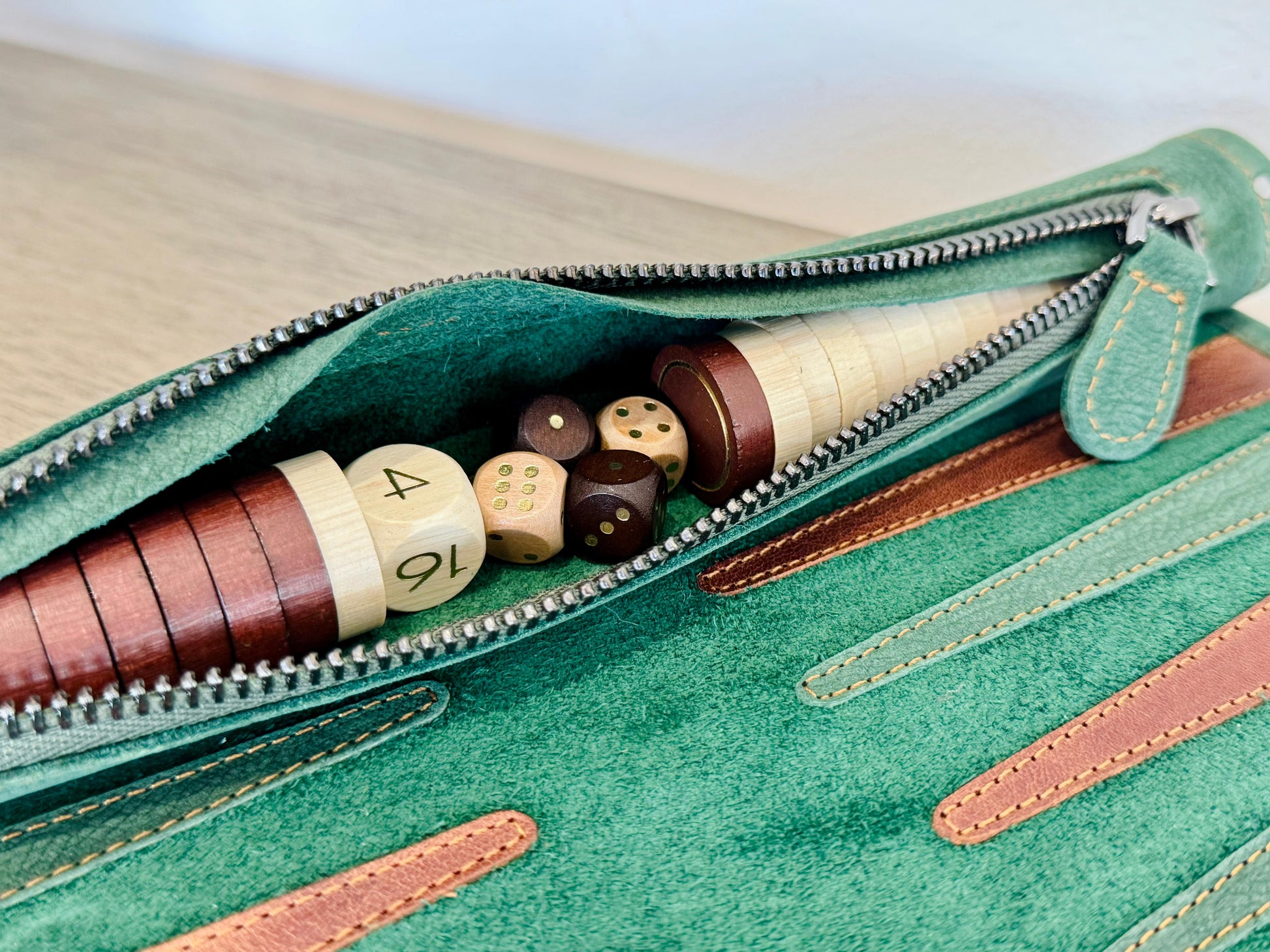 Integrated leather storage for playing pieces inside MELIA Hunter backgammon