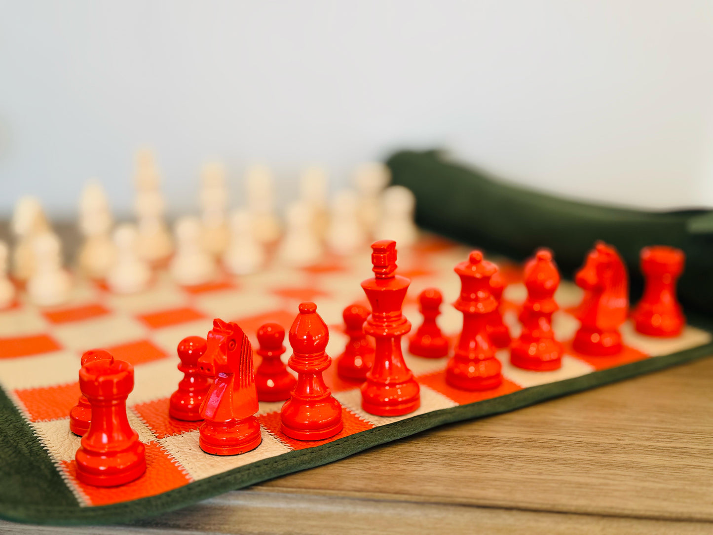 Close-up of orange magnetic chess pieces on the handcrafted leather board